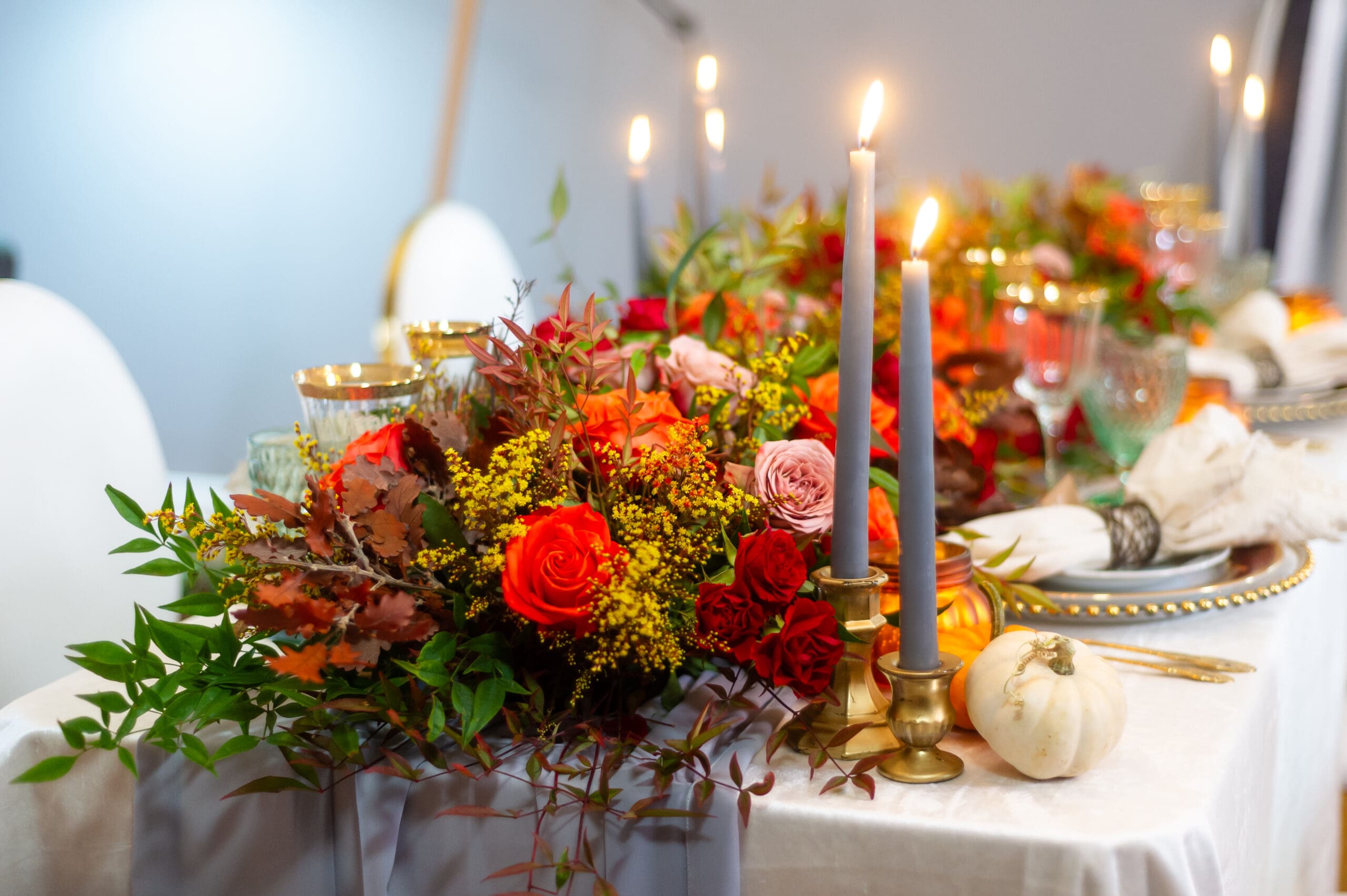 Elegant fall event décor featuring burgundy florals, candlelit tables, and sophisticated autumn styling by an Orlando event planner